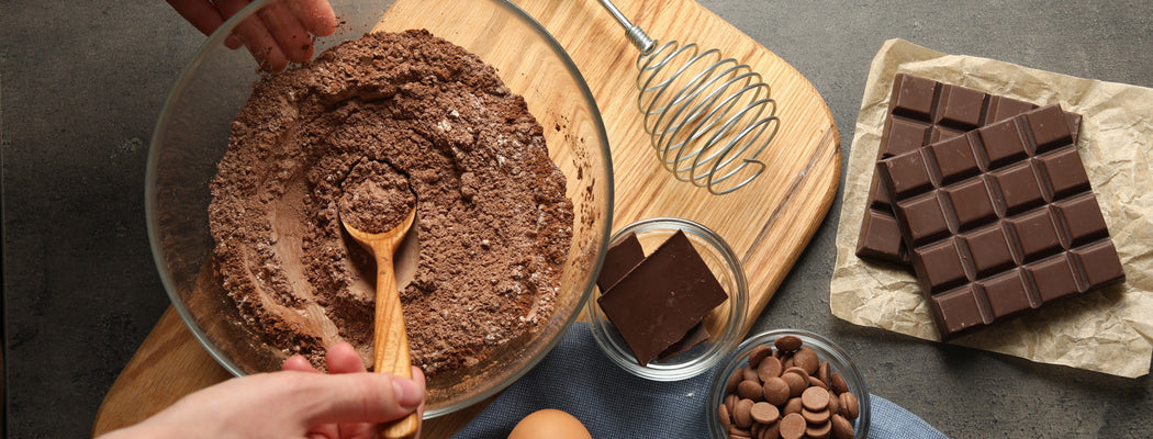 Top view of a woman making brownies with the ingredients on a grey table