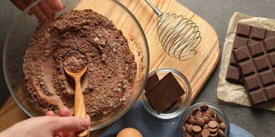 Top view of a woman making brownies with the ingredients on a grey table