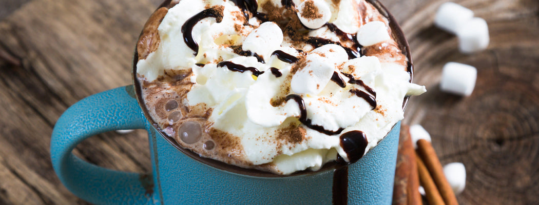 Hot chocolate coffee drink topped with whipped cream and chocolate shavings