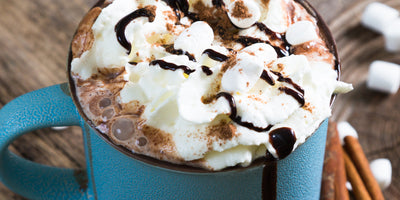 Hot chocolate coffee drink topped with whipped cream and chocolate shavings
