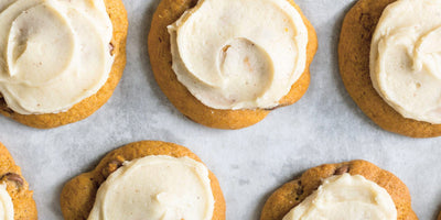 Pumpkin chocolate chip cookies with cream cheese frosting on rack