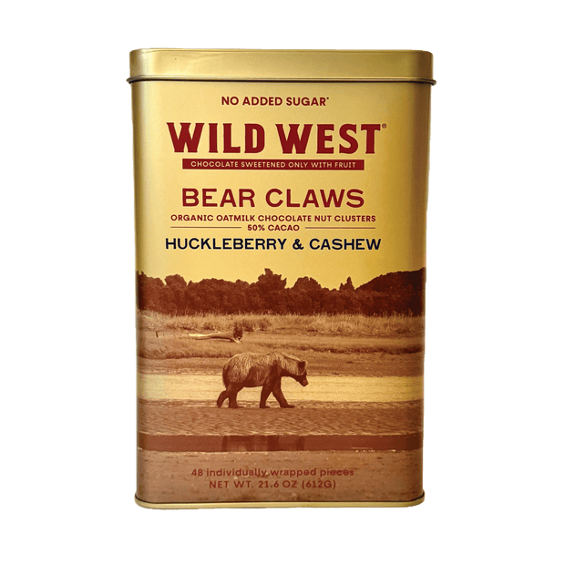 A rectangular gold metal tin of Wild West Bear Claws Chocolate Sweetened Oat Milk Chocolate Nut Clusters (Huckleberry & Cashew flavor) on a plain white background.