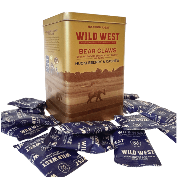 A square gold tin of Wild West Bear Claws chocolate nut clusters with multiple packets scattered around its base on a white background.